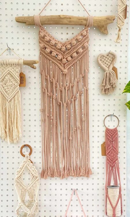 macrame wall hanging on driftwood in ballet pink color